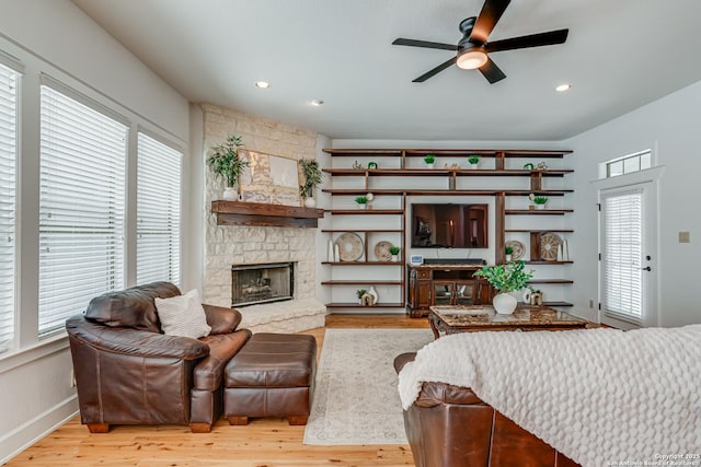 living room featuring ceiling fan, a fireplace, wood finished floors, and recessed lighting