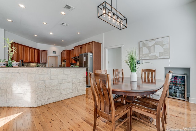 dining area with recessed lighting, beverage cooler, visible vents, and light wood finished floors