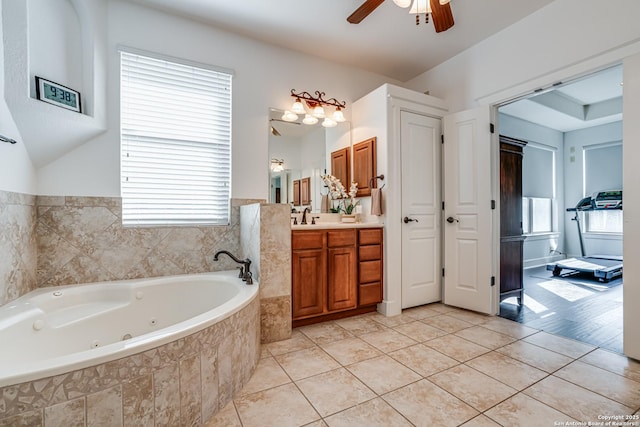 full bath with tile patterned flooring, ceiling fan, vanity, and a tub with jets