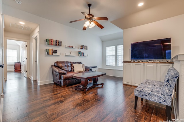 living area featuring dark wood-type flooring, plenty of natural light, and visible vents