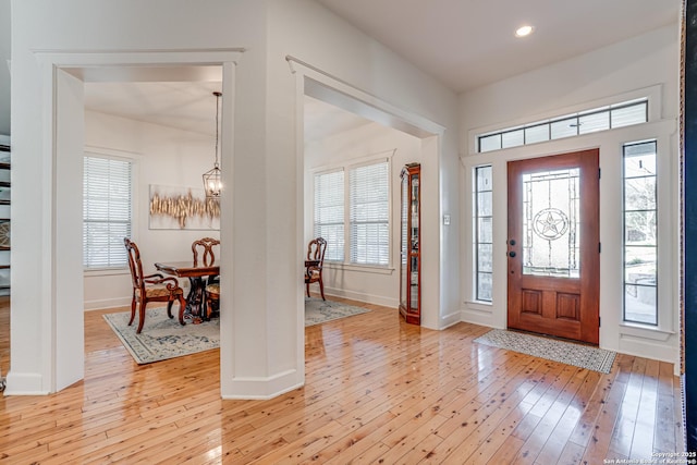 entrance foyer featuring light wood-style floors, baseboards, a chandelier, and recessed lighting