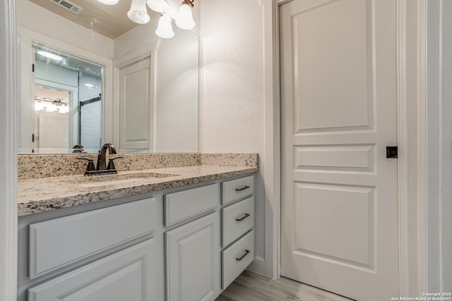 bathroom featuring visible vents, vanity, and wood finished floors