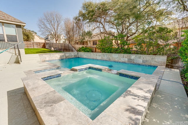 view of pool with a fenced backyard and a pool with connected hot tub