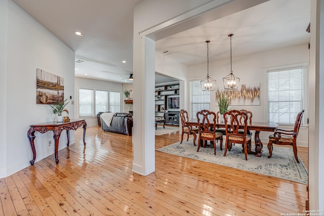 dining space featuring ceiling fan with notable chandelier, light wood-type flooring, and recessed lighting