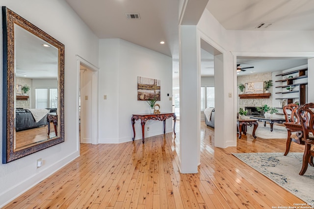 foyer with recessed lighting, a fireplace, visible vents, a ceiling fan, and light wood-style floors