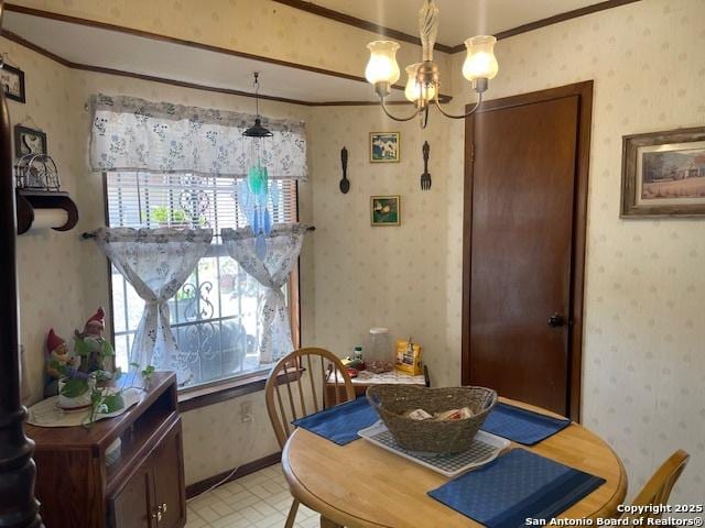 dining space featuring ornamental molding, baseboards, an inviting chandelier, and wallpapered walls