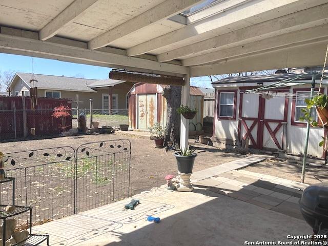 view of patio / terrace with fence private yard, an outdoor structure, and a storage shed