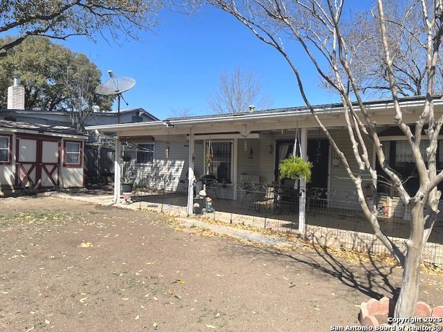 single story home featuring a porch and fence