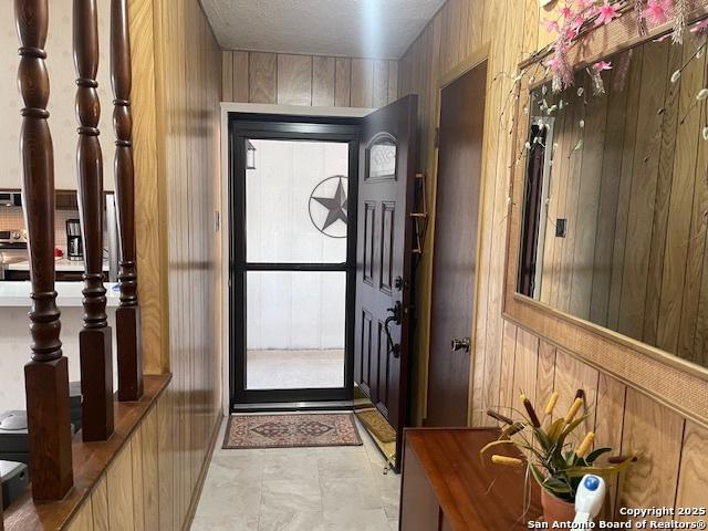 foyer entrance featuring wooden walls