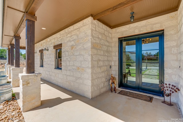 property entrance with stone siding and french doors