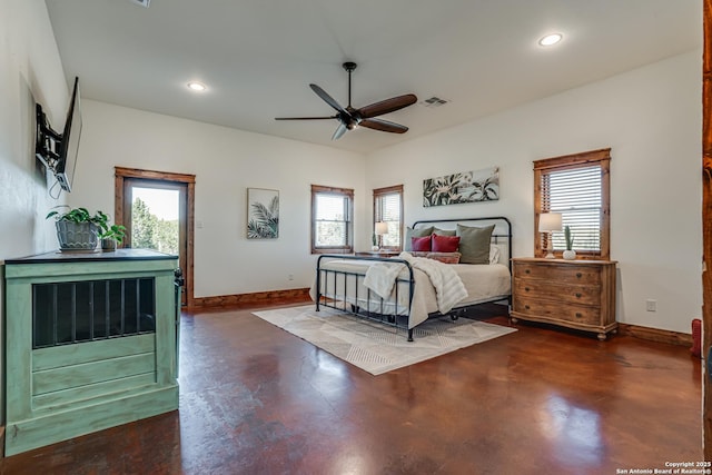 bedroom featuring concrete flooring, multiple windows, and baseboards