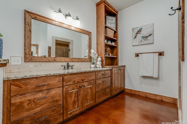 full bathroom with baseboards, vanity, and finished concrete floors