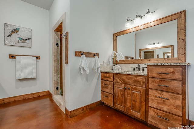 full bathroom with concrete floors, a shower stall, baseboards, and vanity