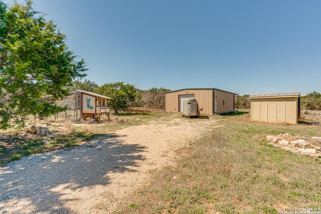 view of yard featuring an outbuilding, driveway, and a detached garage