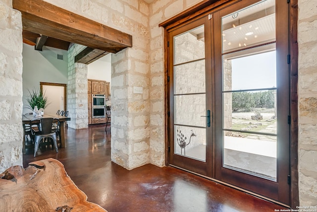 doorway with finished concrete flooring, french doors, visible vents, and ornate columns