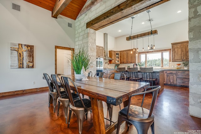 dining area featuring baseboards, visible vents, beamed ceiling, finished concrete floors, and high vaulted ceiling