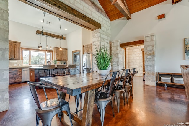 dining space with finished concrete floors, beam ceiling, wooden ceiling, and a high ceiling