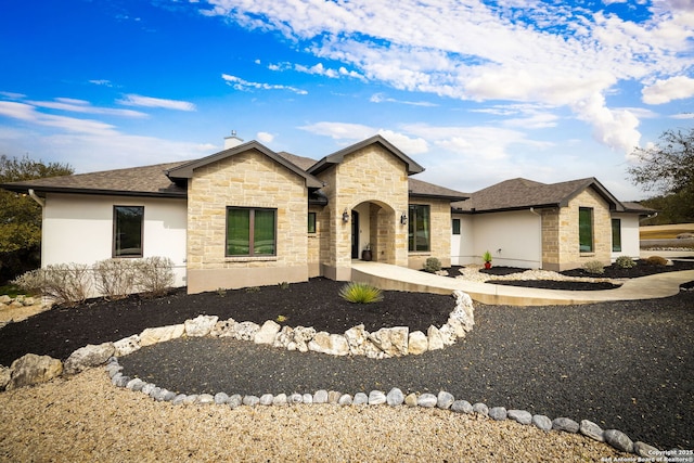 view of front of house with stone siding and a shingled roof