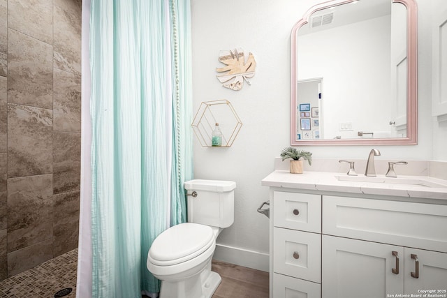 full bath featuring toilet, vanity, visible vents, baseboards, and tiled shower