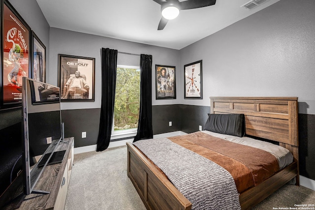 carpeted bedroom featuring a ceiling fan, visible vents, and baseboards