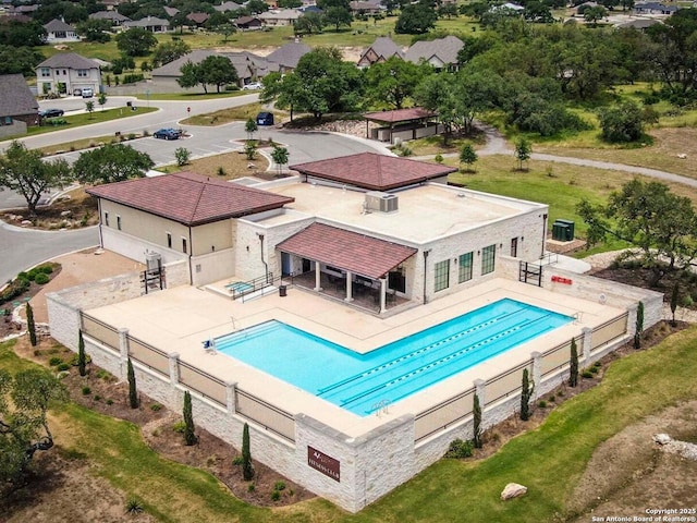 community pool with a patio and fence