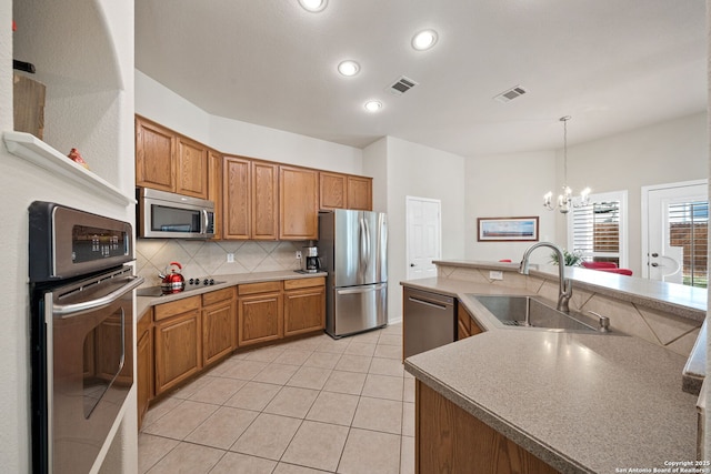 kitchen featuring stainless steel appliances, visible vents, a sink, and tasteful backsplash