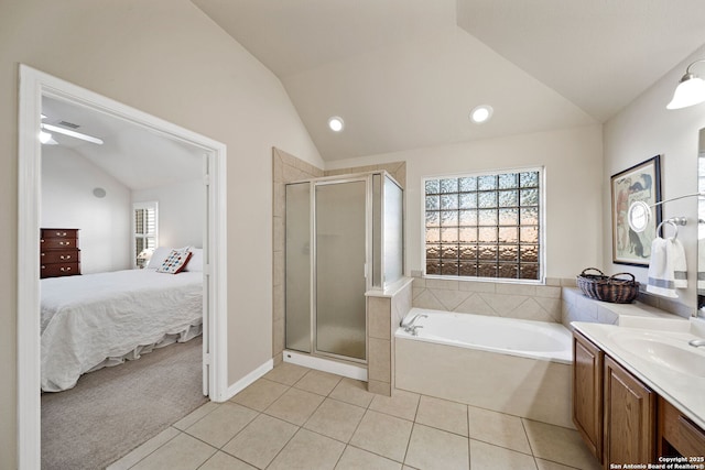 ensuite bathroom featuring lofted ceiling, vanity, tile patterned floors, a stall shower, and ensuite bath