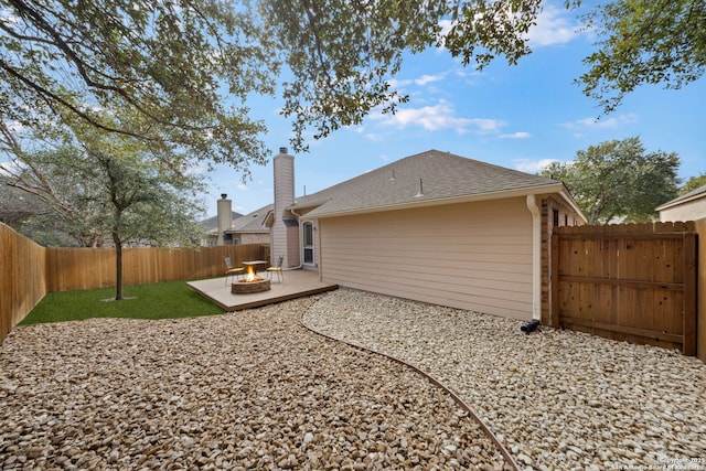 rear view of property with a yard, a fenced backyard, a patio, and roof with shingles