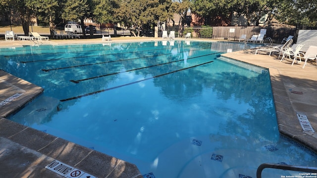 community pool with fence and a patio