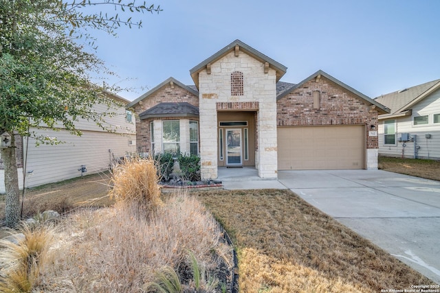 view of front of house with an attached garage, stone siding, concrete driveway, and brick siding