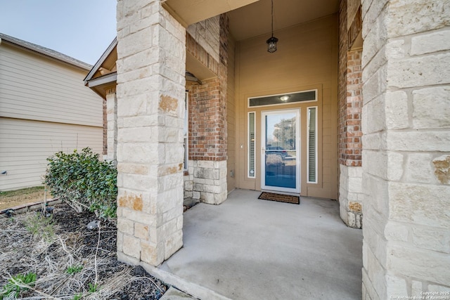 doorway to property with stone siding and brick siding