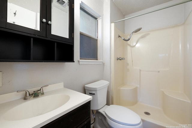 bathroom featuring a shower, vanity, toilet, and a textured ceiling