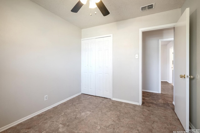 unfurnished bedroom with a textured ceiling, a closet, visible vents, and baseboards