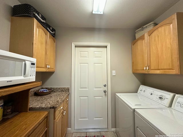 laundry room with cabinet space, a textured ceiling, and independent washer and dryer