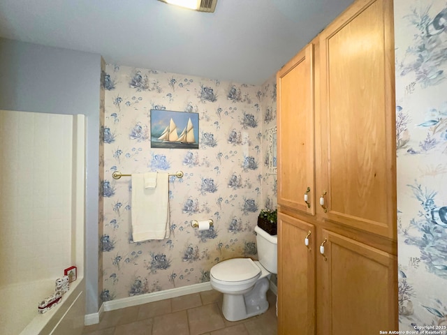 full bath featuring wallpapered walls, baseboards, toilet, tile patterned flooring, and a bath