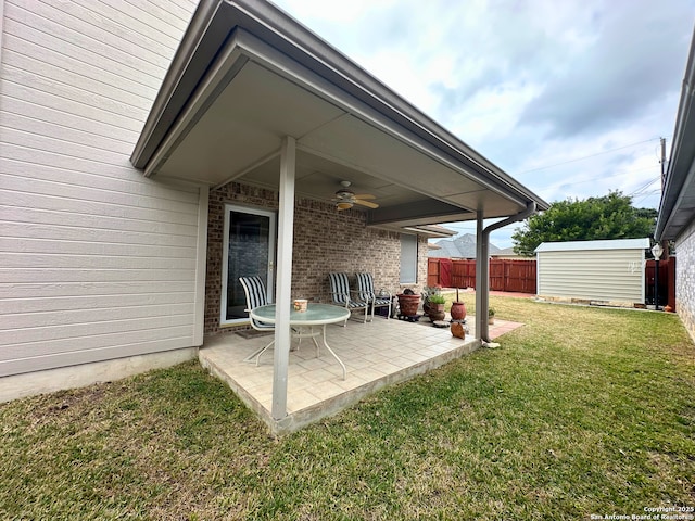 view of patio / terrace with an outbuilding, fence, a storage shed, and ceiling fan