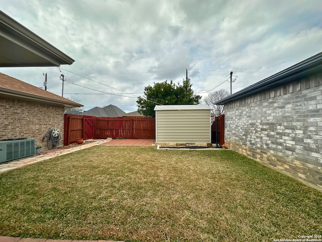 view of yard featuring an outbuilding, central AC, a fenced backyard, and a storage unit