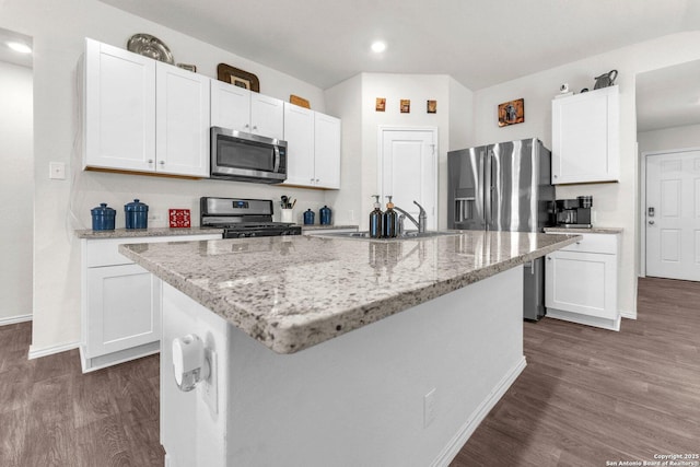 kitchen with stainless steel appliances, white cabinets, dark wood-type flooring, and a kitchen island