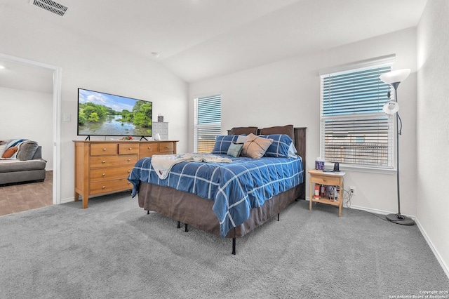 bedroom with visible vents, vaulted ceiling, carpet flooring, and multiple windows