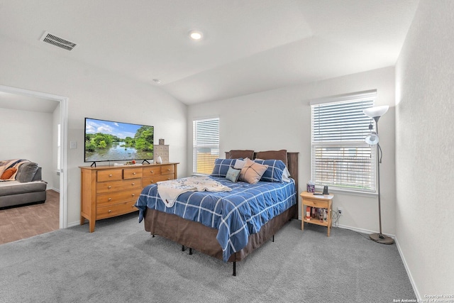 bedroom with light colored carpet, lofted ceiling, visible vents, and multiple windows