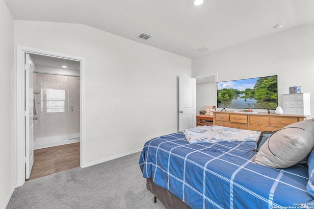 carpeted bedroom with lofted ceiling, ensuite bath, baseboards, and visible vents