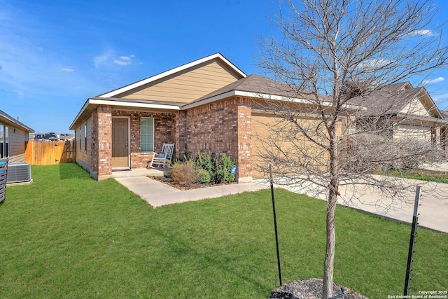 view of front of house featuring brick siding, an attached garage, central AC unit, fence, and a front lawn