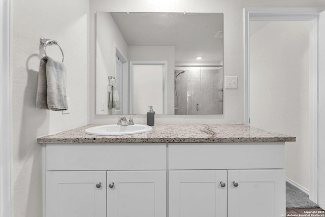 bathroom with a shower stall and vanity