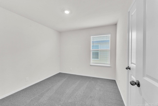 unfurnished room featuring carpet and baseboards