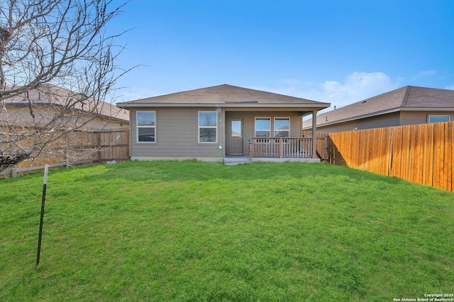 back of house with a yard and a fenced backyard