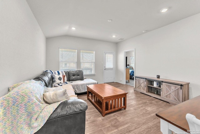 living room featuring lofted ceiling, light wood-style flooring, and recessed lighting