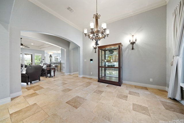 foyer entrance with baseboards, visible vents, arched walkways, and crown molding