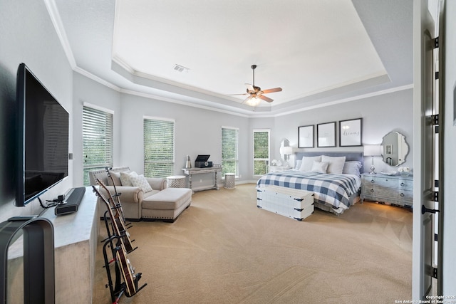 bedroom with multiple windows, visible vents, a raised ceiling, and carpet flooring