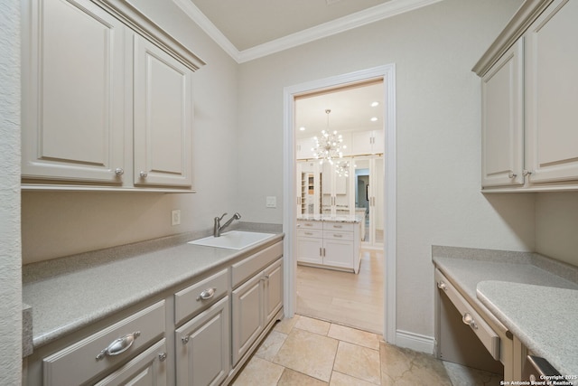 laundry area featuring a notable chandelier, crown molding, and a sink