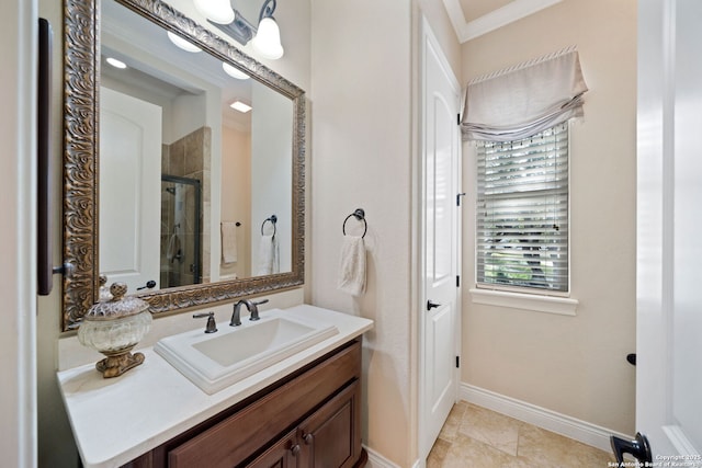 full bath with a stall shower, crown molding, vanity, and baseboards